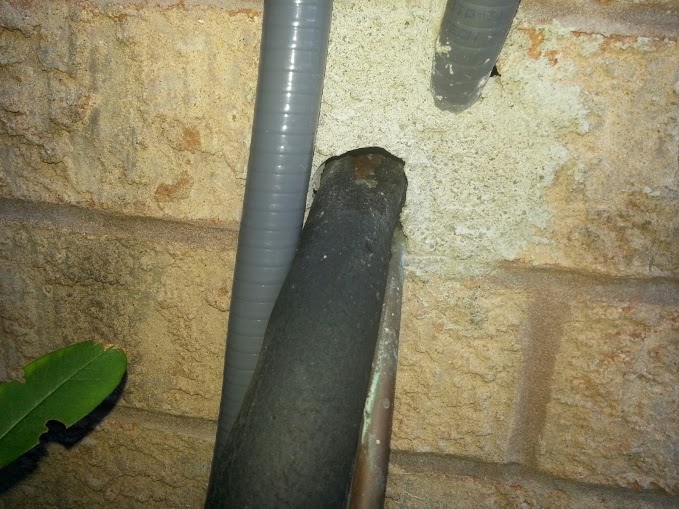 Chewed foam insulator: In this case, concrete was used to fill the gap around the coolant line, but as you can see mice have chewed the foam insulator to access the home. 