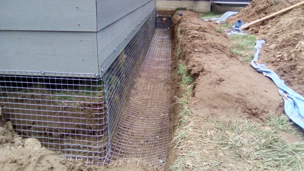 Installing heavy gauge screen and burying it below a deck to prevent skunk entry