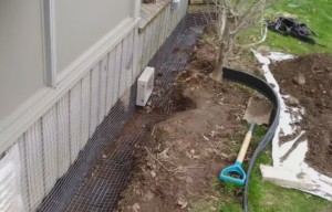 A deep trench dug around the base of a shed with heavy-duty wire mesh screening installed to prevent animal burrowing.